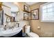 Neutral bathroom featuring unique glass block window, floating wood shelves and round mirror at 3800 Craig Ave, Charlotte, NC 28211