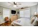 Well-lit bedroom boasts hardwood floors, a ceiling fan and a dresser below the mounted television at 3800 Craig Ave, Charlotte, NC 28211