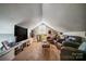 Inviting bonus room has a sloped ceiling, plush carpeting, and plentiful seating around a TV at 3800 Craig Ave, Charlotte, NC 28211