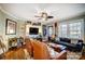 Comfortable living room with hardwood floors, a fan, a fireplace, and large windows for natural light at 3800 Craig Ave, Charlotte, NC 28211