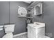 Cozy bathroom featuring a single sink vanity, toilet, and convenient shelving, perfect for storage at 400 37Th Sw St, Hickory, NC 28602
