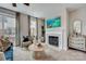 Bright living room featuring a fireplace with a TV above it, chairs, and large windows at 521 Annie Lowery Way, Davidson, NC 28036