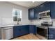 Stylish kitchen with navy cabinets, stainless steel appliances, and a view from the window at 527 Crowell Ave, Statesville, NC 28677