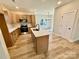Bright kitchen with an island, stainless steel appliances, and wood-look flooring at 613 Granite Ave, Gastonia, NC 28052
