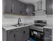 A close-up view of the gray cabinetry, stainless steel appliances, and marble countertops in this kitchen at 621 E Sharpe St, Statesville, NC 28677