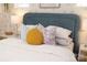 Close up of a comfortable bed with a blue headboard, decorative pillows, and stylish bedside lamps at 7216 Hodges Meadow Ln, Charlotte, NC 28213