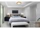 Beautiful bedroom featuring a decorative accent wall, tray ceiling, and a comfortable bed with stylish furnishings at 7216 Hodges Meadow Ln, Charlotte, NC 28213
