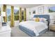 Bright bedroom with large windows, patterned wallpaper, and a blue upholstered bed with decorative pillows at 7216 Hodges Meadow Ln, Charlotte, NC 28213