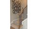 Carpeted stairs with wood railing and black iron balusters with modern wall decor above at 7216 Hodges Meadow Ln, Charlotte, NC 28213