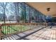 A covered outdoor deck featuring railing detail perfect for entertaining with a wooded backyard at 8082 Golf Course N Dr, Denver, NC 28037