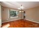 Bright dining room features a large window, elegant chandelier and beautiful hardwood floors at 8082 Golf Course N Dr, Denver, NC 28037