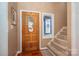 Inviting entryway with stained glass window, beautiful wooden door and staircase at 8082 Golf Course N Dr, Denver, NC 28037