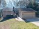 Well-maintained exterior with attached garage and ramp, nestled in a wooded setting at 8082 Golf Course N Dr, Denver, NC 28037