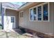 Exterior shot of a home with a white door surrounded by greenery and windows at 8082 Golf Course N Dr, Denver, NC 28037