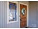 Charming front door with decorative glass, wreath, and sidelight for an inviting entrance at 8082 Golf Course N Dr, Denver, NC 28037