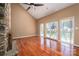 Open-concept living room with a stone fireplace, hardwood floors, and sliding glass doors to the deck at 8082 Golf Course N Dr, Denver, NC 28037