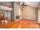 Spacious living room featuring stone fireplace, skylights, vaulted ceiling, and gleaming hardwood floors at 8082 Golf Course N Dr, Denver, NC 28037
