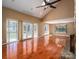 Bright and spacious living room featuring a stone fireplace, hardwood floors, and access to the outdoor deck at 8082 Golf Course N Dr, Denver, NC 28037