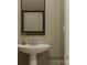 A stylish half bath features a modern pedestal sink, sleek faucet, and decorative framed artwork at 8421 Norman Forest Rd, Lancaster, SC 29720
