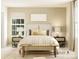Inviting bedroom featuring a cozy bed, bedside lamps, and a bench with ample natural light at 8421 Norman Forest Rd, Lancaster, SC 29720
