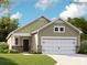 Charming single-story home showcasing stone accents and a two-car garage under a clear blue sky with sparse trees nearby at 8426 Norman Forest Rd, Lancaster, SC 29720