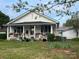 Charming cottage with inviting porch, enhanced by flower boxes, hanging baskets, and a well-kept lawn at 1001 N Cannon Blvd, Kannapolis, NC 28083