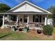 Charming home with a cozy front porch and beautifully landscaped front yard filled with potted plants and flowers at 1001 N Cannon Blvd, Kannapolis, NC 28083