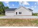 Exterior view of a modern farmhouse with a white garage and driveway, showcasing its clean lines at 1037 Dameron Rd, Bessemer City, NC 28016
