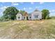 Charming white farmhouse featuring a welcoming front porch and black front door with a well-manicured lawn at 1037 Dameron Rd, Bessemer City, NC 28016