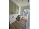 New laundry room with olive green cabinets, a utility sink, and light hardwood floors at 1037 Dameron Rd, Bessemer City, NC 28016