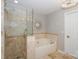 Bright bathroom featuring a soaking tub, glass-enclosed shower, and decorative mirror at 107 Pier 33 Dr # 103, Mooresville, NC 28117