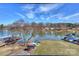 Expansive lake view featuring a dock, boat lifts, and canoes on a sunny day with blue skies and scattered clouds at 107 Pier 33 Dr # 103, Mooresville, NC 28117