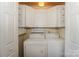 Well-lit laundry room with a stacked washer and dryer and white cabinets at 107 Pier 33 Dr # 103, Mooresville, NC 28117