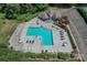 Aerial view of a community pool surrounded by lounge chairs and tables with umbrellas at 107 Pier 33 Dr # 103, Mooresville, NC 28117