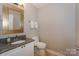 Powder room featuring granite vanity and a decorative mirror at 107 Pier 33 Dr # 103, Mooresville, NC 28117