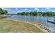 Scenic waterfront featuring a grassy shoreline reinforced with rocks, a calm lake, and boat docks under a sunny sky at 107 Pier 33 Dr # 103, Mooresville, NC 28117