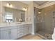 Bathroom featuring double sinks, a large mirror, and a glass-enclosed shower at 107 W Poindexter Dr, Charlotte, NC 28203