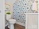 Half-bathroom featuring patterned wallpaper, a toilet, and a vanity with elegant fixtures at 107 W Poindexter Dr, Charlotte, NC 28203