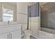 Bathroom featuring a shower-tub combo with a tiled wall and neutral vanity at 107 W Poindexter Dr, Charlotte, NC 28203