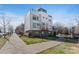 Modern townhome boasts a striking architectural design with a combination of white siding and brick accents at 107 W Poindexter Dr, Charlotte, NC 28203