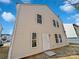 Exterior shot of the rear of the home, featuring neutral siding and a walk-out door at 1121 Swearngan Ridge Ct, Charlotte, NC 28216
