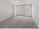 Large bedroom with neutral carpeting, paint and two large windows at 1121 Swearngan Ridge Ct, Charlotte, NC 28216