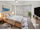 Bright main bedroom with light wood furniture, a large bed, and a cool accent rug at 1121 Swearngan Ridge Ct, Charlotte, NC 28216