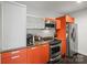 Modern kitchen with stainless steel appliances, orange cabinets, and granite countertops at 1133 Metropolitan Ave # 318, Charlotte, NC 28204