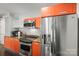 Modern kitchen featuring stainless steel appliances, orange cabinetry, and granite countertops at 1133 Metropolitan Ave # 318, Charlotte, NC 28204