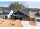 Aerial view of the two-story home with dark wood siding, new landscaping, and long driveway at 123 Mills Garden Rd, Statesville, NC 28625