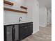 Modern bar area featuring dark cabinets, a beverage fridge, open shelving, and a marble countertop at 123 Mills Garden Rd, Statesville, NC 28625