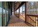 Long covered porch features wood railings, ceiling fans, and views of the wooded backyard at 123 Mills Garden Rd, Statesville, NC 28625