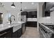 Open kitchen with dark cabinets, stainless steel appliances, a farmhouse sink, and marble countertops at 123 Mills Garden Rd, Statesville, NC 28625