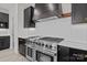 Modern kitchen featuring stainless steel range, dark cabinets, white countertops, and modern lighting fixtures at 123 Mills Garden Rd, Statesville, NC 28625